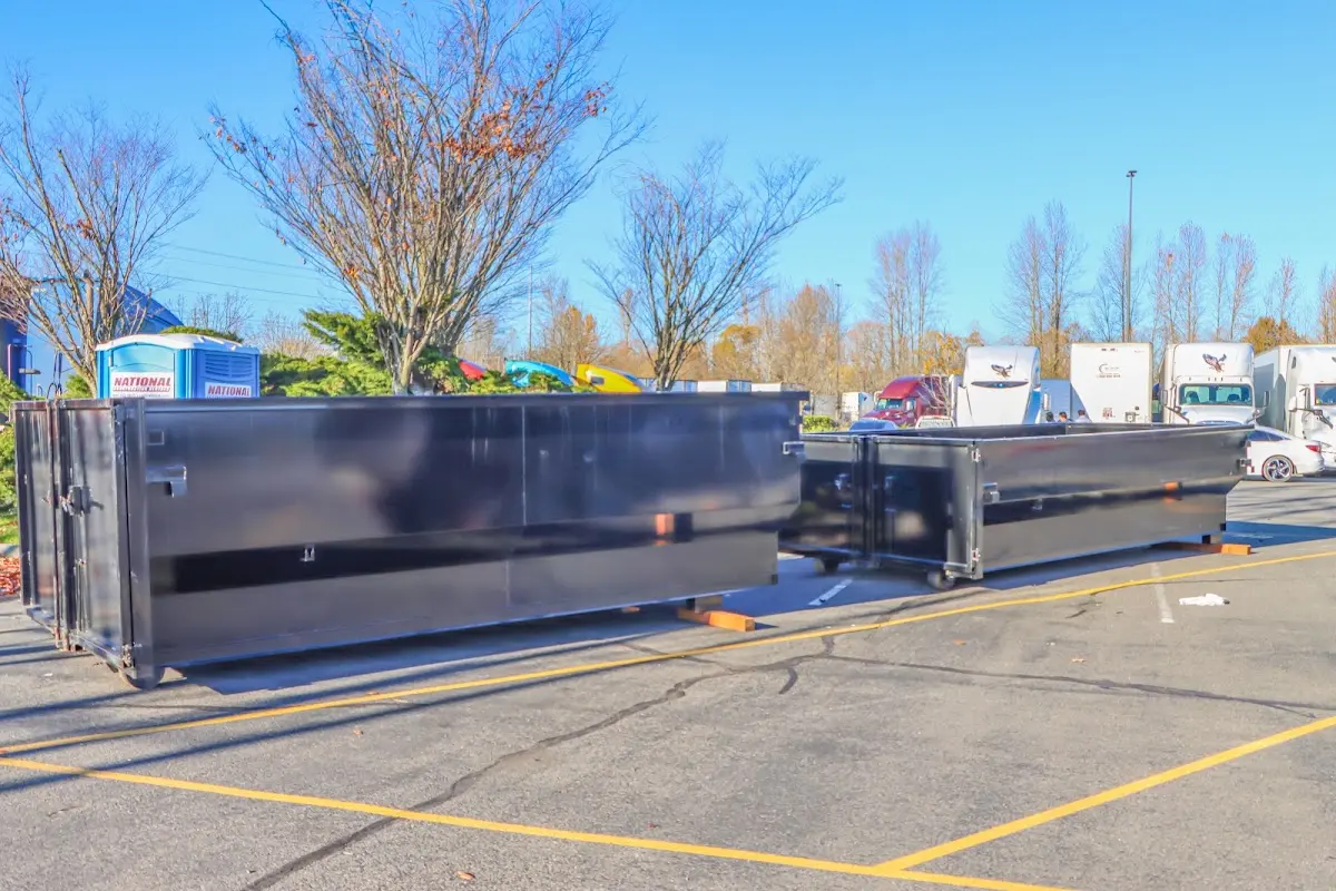 Professional dumpster rental service with roll-off container on residential driveway in Prien
